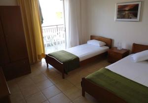 a hotel room with two beds and a window at Harilaos Beach in Plaka Litochorou