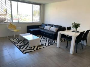 uma sala de estar com um sofá e uma mesa em Linden Court Broadbeach em Gold Coast