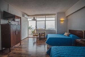 a hotel room with two beds and a table with a view at Hotel Palacio in Córdoba