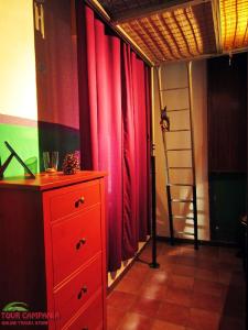 a room with red curtains and a dresser and a ladder at B&B Historic Centre Naples in Naples