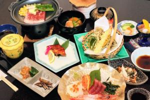 a table topped with plates of food and bowls of food at ホテル縁の杜 山中湖 in Yamanakako