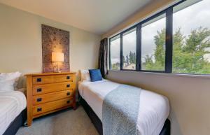 1 dormitorio con 2 camas y ventana en *** LAKE VILLA 467 ***, en Hanmer Springs