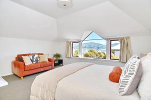 ein Schlafzimmer mit einem großen Bett und einem Fenster in der Unterkunft Tumeke Akaroa - Apartment - Christchurch Holiday Homes in Akaroa