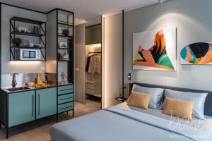 a bedroom with a blue bed and a mirror at Bare Chic - Bare Boutique Stays in Ho Chi Minh City