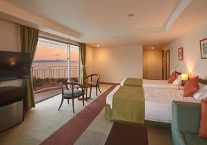 a hotel room with two beds and a balcony at Hotel Yugaf Inn Okinawa in Nago