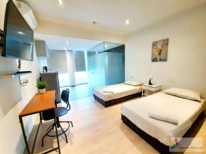 a hotel room with two beds and a desk and a desk at International Service Apartments at Raeburn Park in Singapore