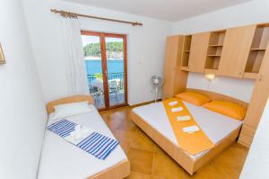 two beds in a room with a view of the ocean at Apartments Moloco in Drvenik