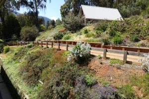 einen Garten auf einem Hügel mit einem Zaun in der Unterkunft Elkanah Lodge and Conference Centre in Marysville