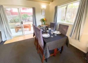 a dining room with a table and chairs and windows at Hideaway Rima - in the CBD in Queenstown