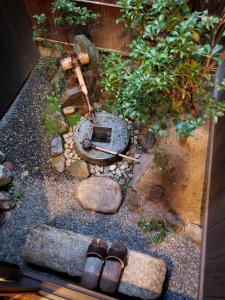 un jardin miniature avec deux paires de chaussures sur le sol dans l'établissement Machiya Kaemon, à Kyoto