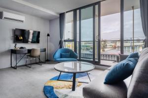 uma sala de estar com um sofá e uma mesa em Oros Hotel and Apartments em Oakleigh