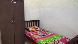 1 dormitorio pequeño con 1 cama y armario en Yellow House, en Sunggal