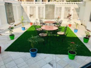 a patio with a table and chairs and plants at Royal Heritage Villa Udaipur in Udaipur