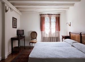 a bedroom with a bed and a television and a window at Hotel IRARAGORRI in Galdakao