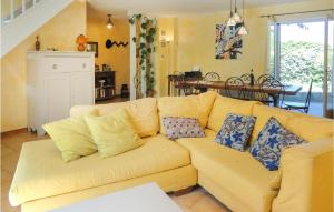 eine gelbe Couch mit Kissen in einem Wohnzimmer in der Unterkunft Beautiful Home In Nissan Lez Enserune in Nissan-lez-Enserune