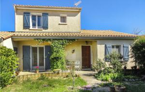 ein weißes Haus mit blauen Fenstern und einem Garten in der Unterkunft Beautiful Home In Nissan Lez Enserune in Nissan-lez-Enserune