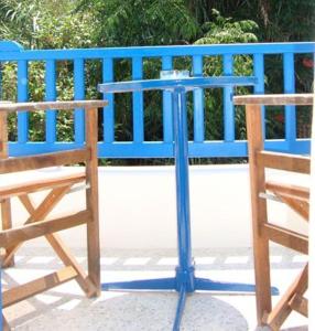 a blue fence next to a chair and a table at Hotel Minoa in Katapola