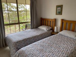 a bedroom with two beds and a large window at Windmill Cottage in Clare