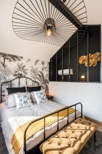 リヨンにあるLe Cocon Des Artistesのベッドルーム1室(大型ベッド1台、大きなシャンデリア付)