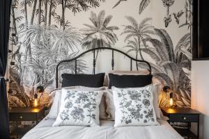 リヨンにあるLe Cocon Des Artistesのベッドルーム1室(トロピカルな壁紙のベッド1台付)
