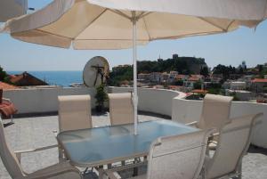 a table and chairs with an umbrella on a balcony at Apartments Ismy in Ulcinj