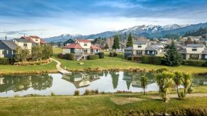 a suburb with houses and a lake in front of mountains at *** LAKE VILLA 467 *** in Hanmer Springs