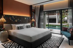 a bedroom with a large bed and a swimming pool at Grand Mercure Khao Lak Bangsak in Khao Lak