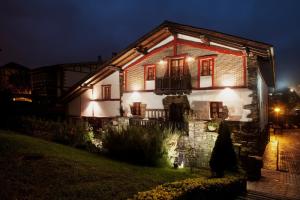 a house with lights on the side of it at night at Hotel IRARAGORRI in Galdakao