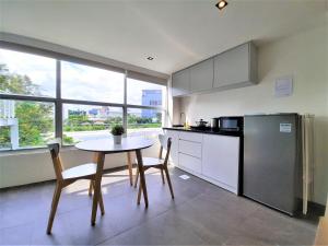 a kitchen with a table and chairs and a refrigerator at International Service Apartments at Raeburn Park in Singapore