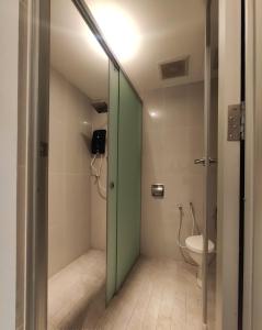 a bathroom with a toilet and a green door at T Hotel Tandop in Alor Setar