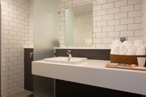 a bathroom with a sink and a mirror and towels at Sangsang Stay Busan in Busan