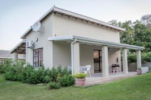 a white house with a patio in a yard at 870 on Riverview Drive in Mtubatuba