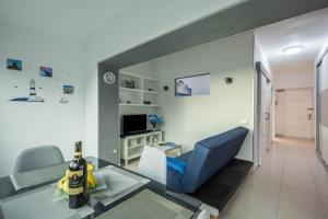 een woonkamer met een blauwe bank en een tafel bij Estudio Bel Air in Puerto de la Cruz