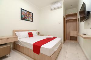 1 dormitorio con 1 cama y TV en RedDoorz Syariah @ Cinere Depok en Depok