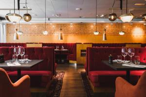 a restaurant with red booths and tables with wine glasses at Hotel Rival in Stockholm