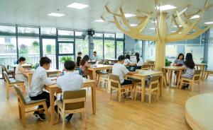 un groupe de personnes assises à table dans un restaurant dans l'établissement Techgarden Workstay Dorm - Coworking Space, à Hanoï