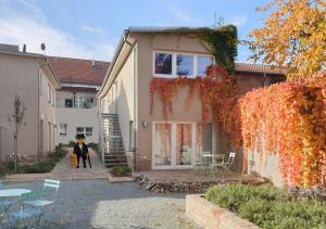 una persona in piedi di fronte a una casa di Travel Art Boardinghouse a Neuruppin