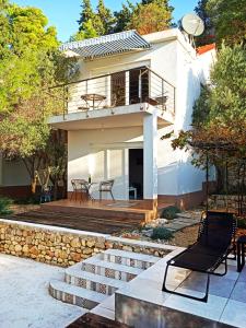 a house with a staircase leading to a patio at Quercus Apartment in Stara Baška