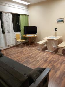 a room with a couch and a desk and a tv at Ruskalinna Apartments in Pello