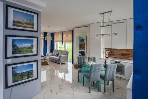 a kitchen and living room with a table and chairs at GOLF APARTAMENT W Sobieniach in Sobienie Jeziory