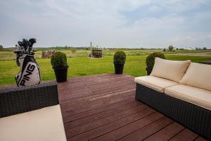 a wooden deck with a couch and some plants at GOLF APARTAMENT W Sobieniach in Sobienie Jeziory