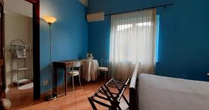 una camera con tavolo e parete blu di Fabiola B & B a Marino