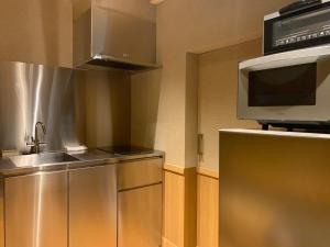 a kitchen with a sink and a microwave at Gion Suite in Kyoto