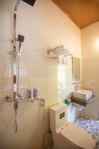 une salle de bain avec toilettes, lavabo et douche dans l'établissement Hang Múa Village Homestay, à Ninh Binh