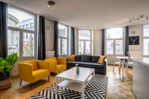 a living room with yellow chairs and a couch at Smartflats - Central Ghent in Ghent