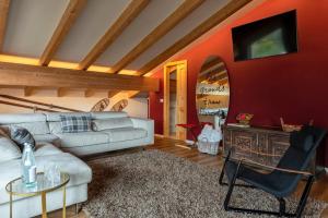 un soggiorno con divano e tavolo di Alp Wellness Sport Hotel Panorama a Fai della Paganella