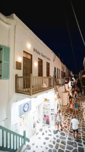 a group of people standing outside of a white surf shop at White Sand Suites Mykonos in Mikonos