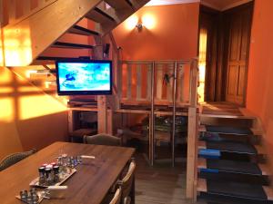 a room with a table with a television and a staircase at HeRo 4 Sterne Ferienhaus in Baja