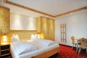 A bed or beds in a room at Kaiserhotel Kitzbühler Alpen