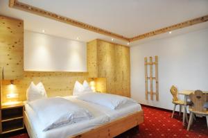 オーベルンドルフ・イン・チロルにあるKaiserhotel Kitzbühler Alpenのベッドルーム(大きな白いベッド1台、テーブル付)